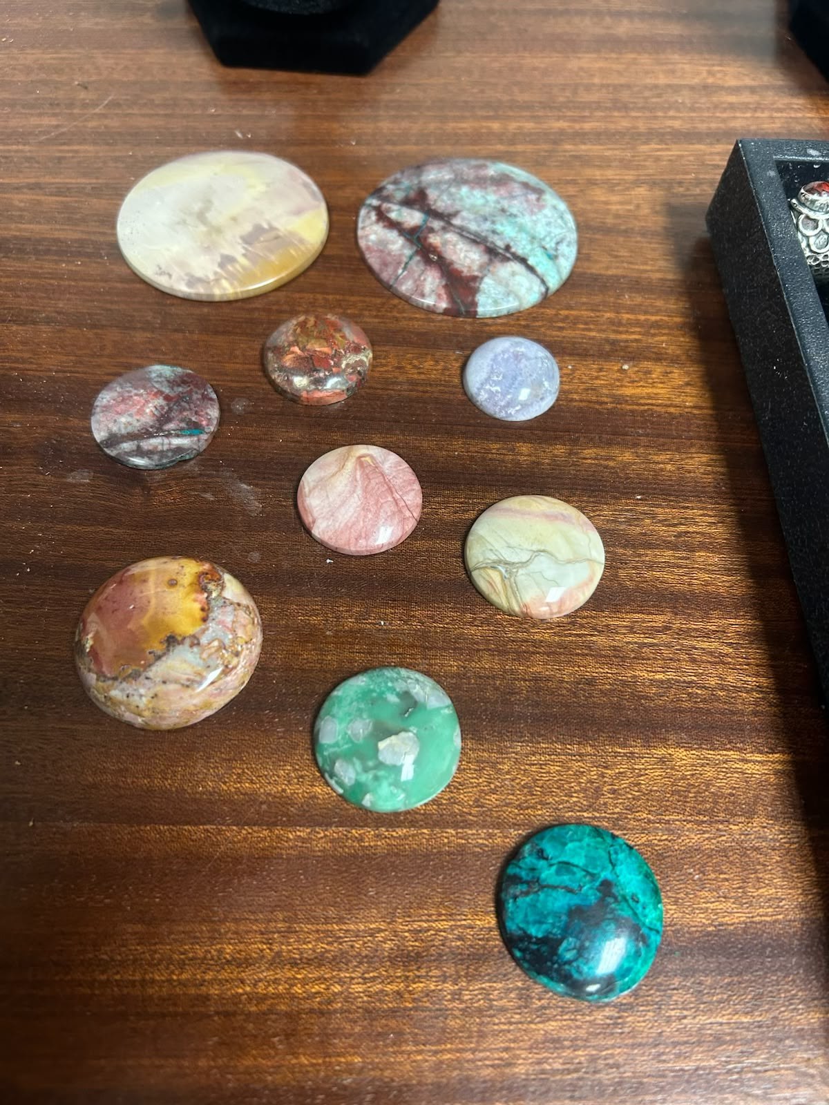 A spread of finished cabochons, domed and shining, just off the wheel.